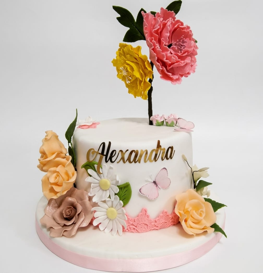 Torta blanca decorada con flores de azúcar hechas a mano: peonía, rosas y margaritas